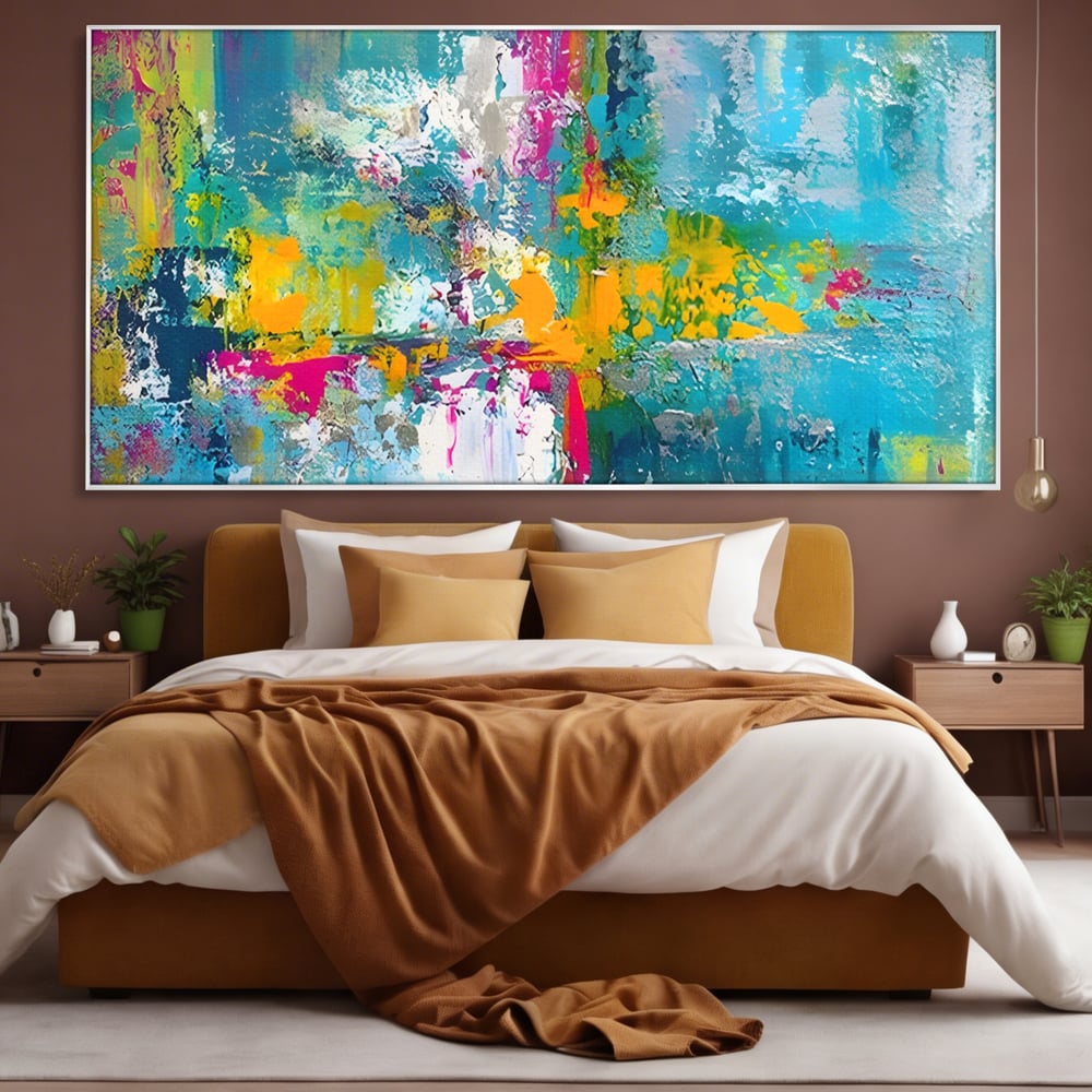 Tablou canvas cu pictura abstracta cu pete albastre si galbene, in rama de aluminiu argintiu, pe perete intr-un dormitor